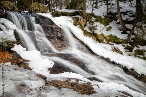waterfall in snowy winter forest