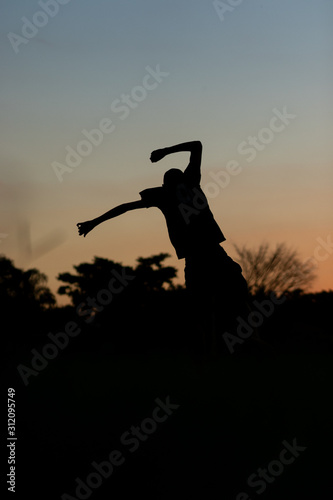 silhouette of a man jumping in sunset