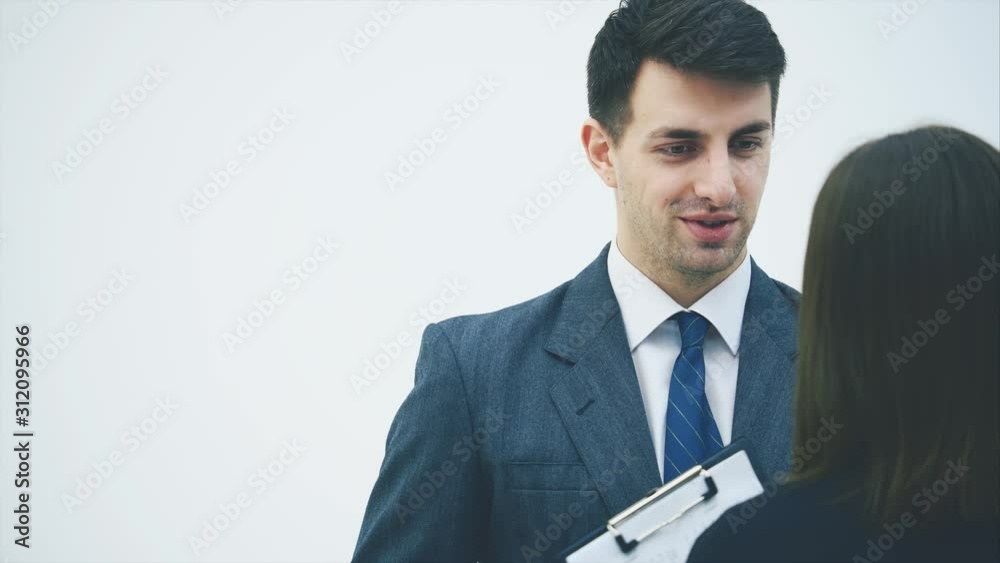 Business man and woman are talking, discussing serious issues. Woman standing with her back to the camera. Business man and woman are talking, discussing serious issues. Woman standing with her back to the camera.