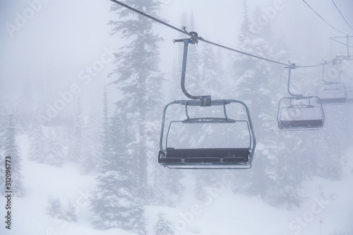Whistler, British Columbia, Canada. Ski Lift Chairs on the Mountain during a cloudy and foggy winter day.