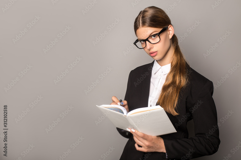 businesswoman writing in notebook isolated on grey businesswoman writing in notebook isolated on grey