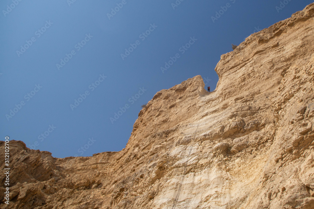 People abseiling in the mountains of Judaean Desert. Dead Sea area, Israel.