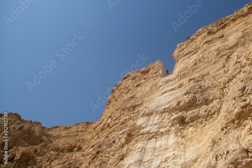 People abseiling in the mountains of Judaean Desert. Dead Sea area, Israel.