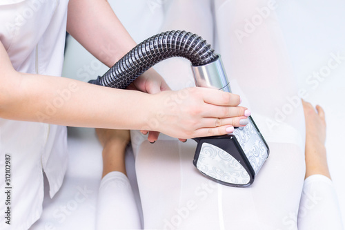lpg girl body massage in spa. The girl is given a hardware massage, she is wearing a special jumpsuit for massage. cavitation, cellulite, fat loss. vacuum roller massage. maniple