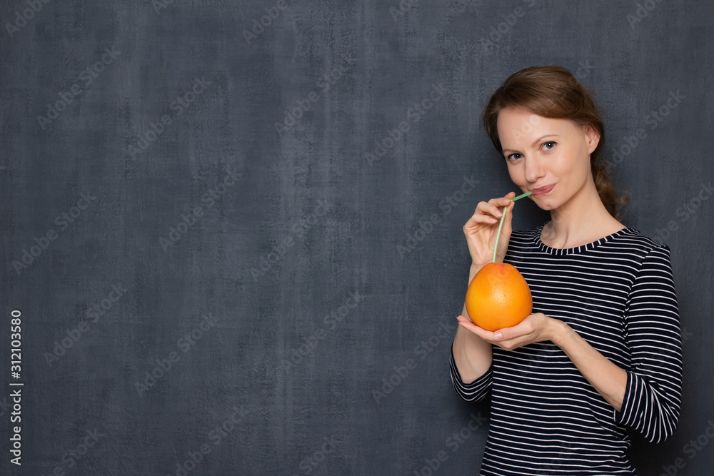 Portrait of happy girl drinking fresh grapefruit juice through straw Portrait of happy girl drinking fresh grapefruit juice through straw