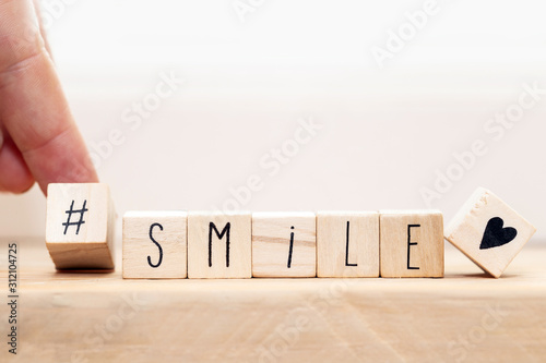 Wooden cubes with a Hashtag and the word smile, social media concept background