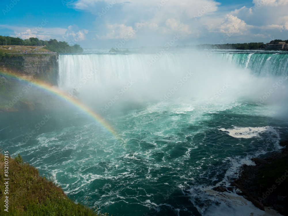 Beautiful rainbow on sunny day over Niagara Falls pool with Horseshow Falls in background Beautiful rainbow on sunny day over Niagara Falls pool with Horseshow Falls in background