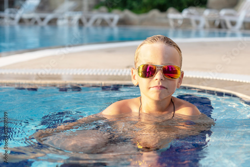boy in sunglasses in the pool. concept of travel, summer, vacation, recreation and childhood