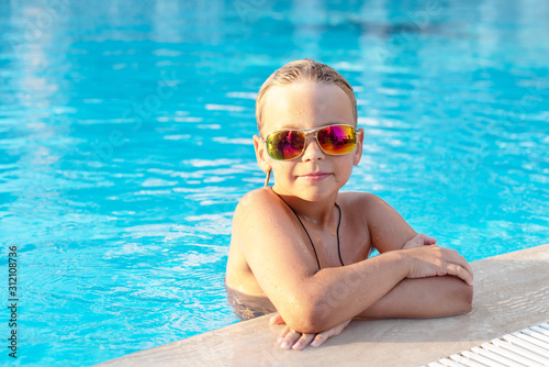 boy in sunglasses in the pool. concept of travel, summer, vacation, recreation and childhood