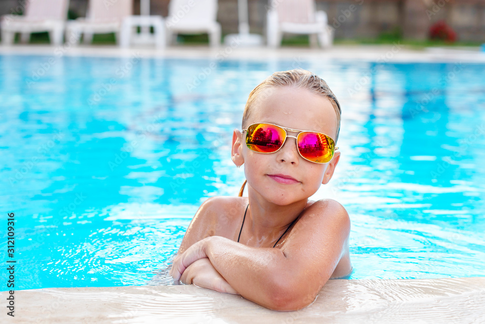 boy in sunglasses in the pool. concept of travel, summer, vacation, recreation and childhood
