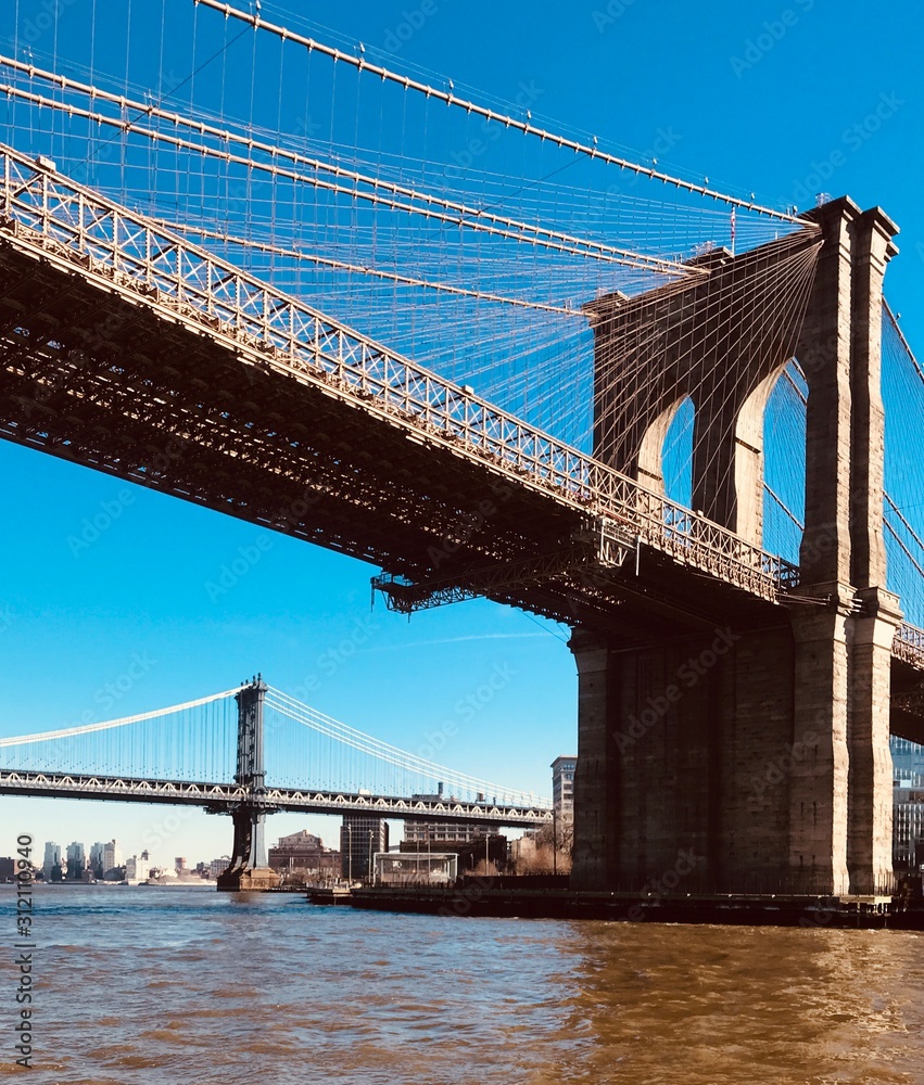 Brooklyn Bridge towering over Hudson river Brooklyn Bridge towering over Hudson river