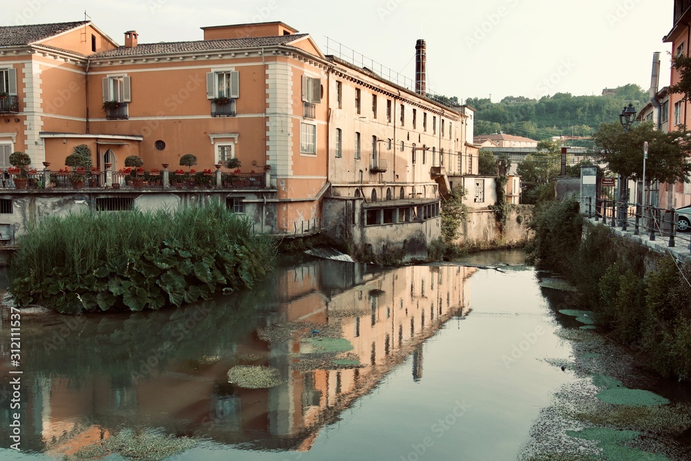 Vintage Italian building reflecting over river