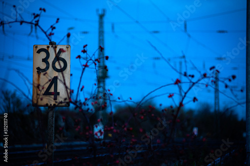 Schild an einer Bahnstrecke mit mystischem Hintergrund