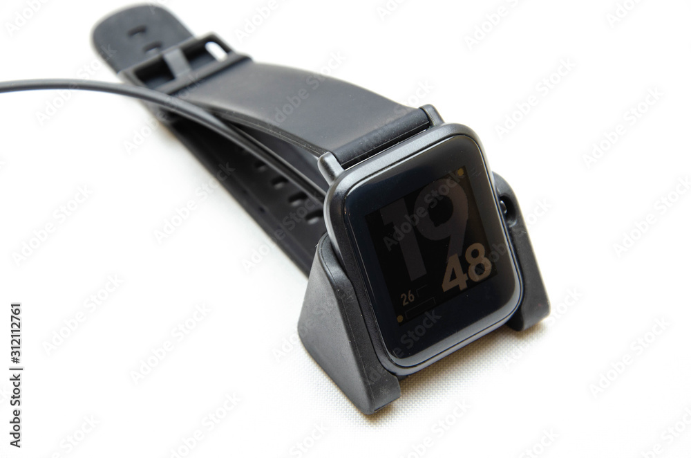 Smart watch on hand. Smart watch on a white background. Charger for smart watches. Dock station. Men's hands hold a smart watch and put them on charge. Watch, charger in close-up Smart watch on hand. Smart watch on a white background. Charger for smart watches. Dock station. Men's hands hold a smart watch and put them on charge. Watch, charger in close-up