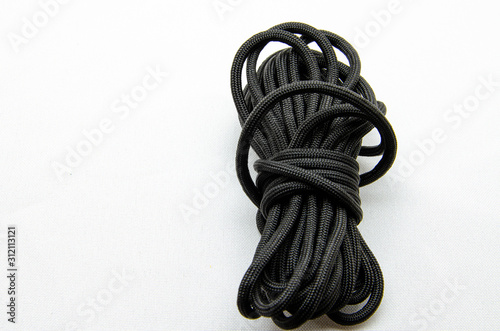 Rope Paracord. Paracord for weaving and tourism. Safety rope rope. Black tactical paracord on a white background and in the hands