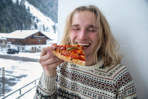 handsome guy eating christmas pizza