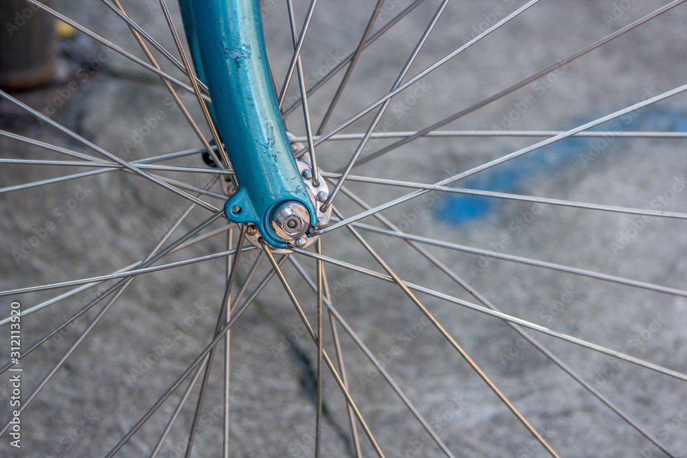 Fototapeta premium Metal bicycle wheel spoke on a blue bike