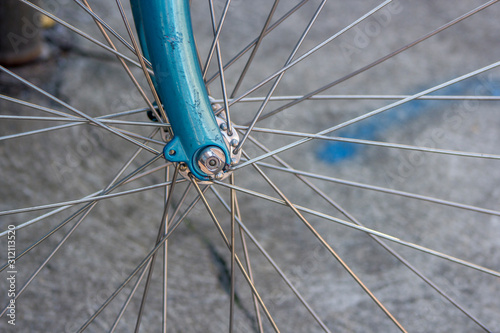 Metal bicycle wheel spoke on a blue bike