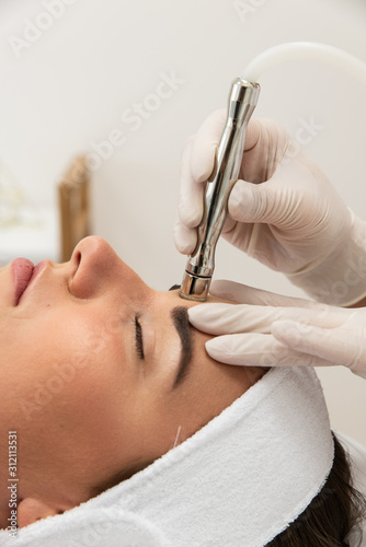 Piękna kobieta podczas zabiegu kosmetycznego mikrodermabrazja urządzenie do pielęgnacji cery