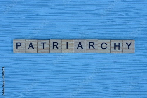 gray word patriarchy from small wooden letters on a blue table photo