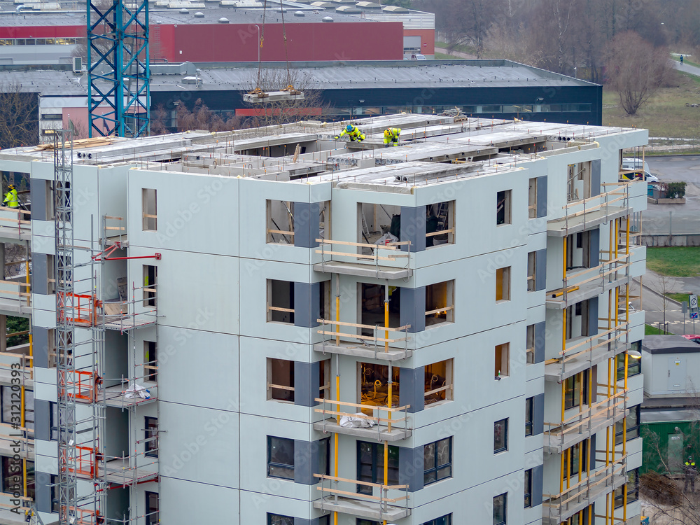Φωτογραφία Builders with crane building multistorey house