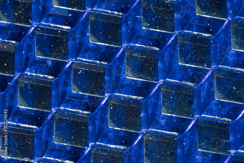 A close up abstract macro photo of a plastic reflector lit with a blue flash gel photo