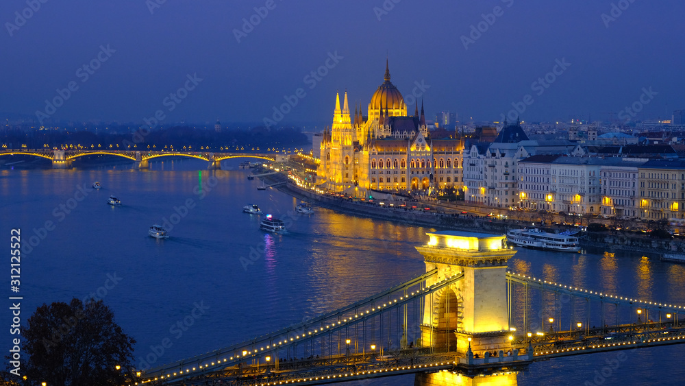 Budapest city at blue hour with illuminated Hungarian Parliament and Chain Bridge over Danube River. Panoramic view.