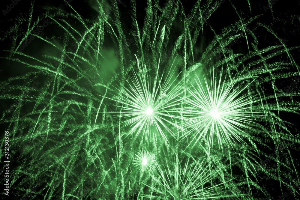 Luxury fireworks event sky show with green big bang stars. Premium entertainment magic star firework at e.g. New Years Eve or Independence Day party celebration. Black dark night background