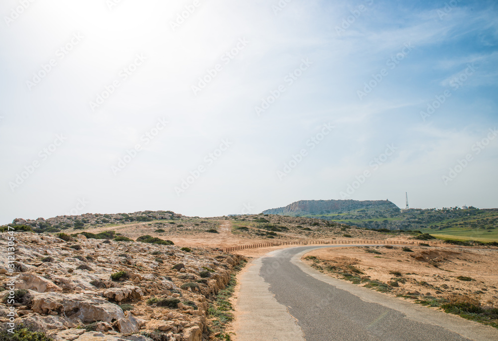 Asphalt road leading to small mountain in Cavo Greco