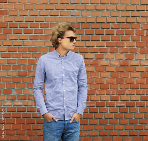 Teenager standing near a brick wall 