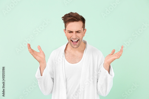 Happy man in bathrobe on co...