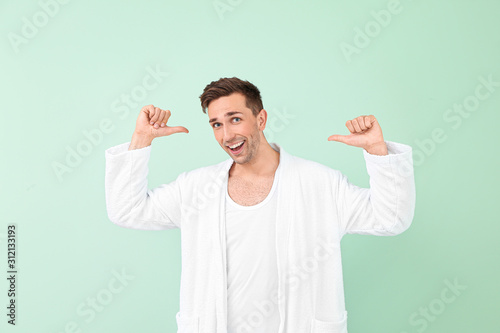 Happy man in bathrobe showi...