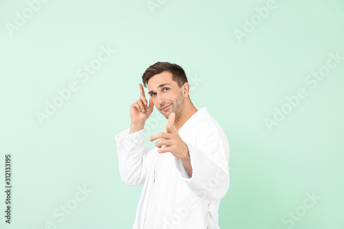 Handsome man in bathrobe po...