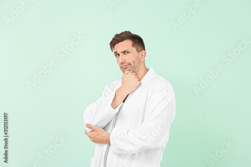 Thoughtful man in bathrobe ...
