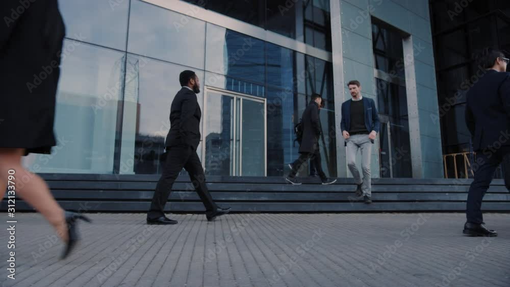 Office Managers and Business People Commute to Work in the Morning or from Office on a Cloudy Day in Downtown on Foot. Pedestrians are Smart Casually Dressed. Successful People Holding Smartphones. Office Managers and Business People Commute to Work in the Morning or from Office on a Cloudy Day in Downtown on Foot. Pedestrians are Smart Casually Dressed. Successful People Holding Smartphones.