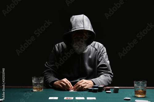 Male cardsharper playing in casino photo