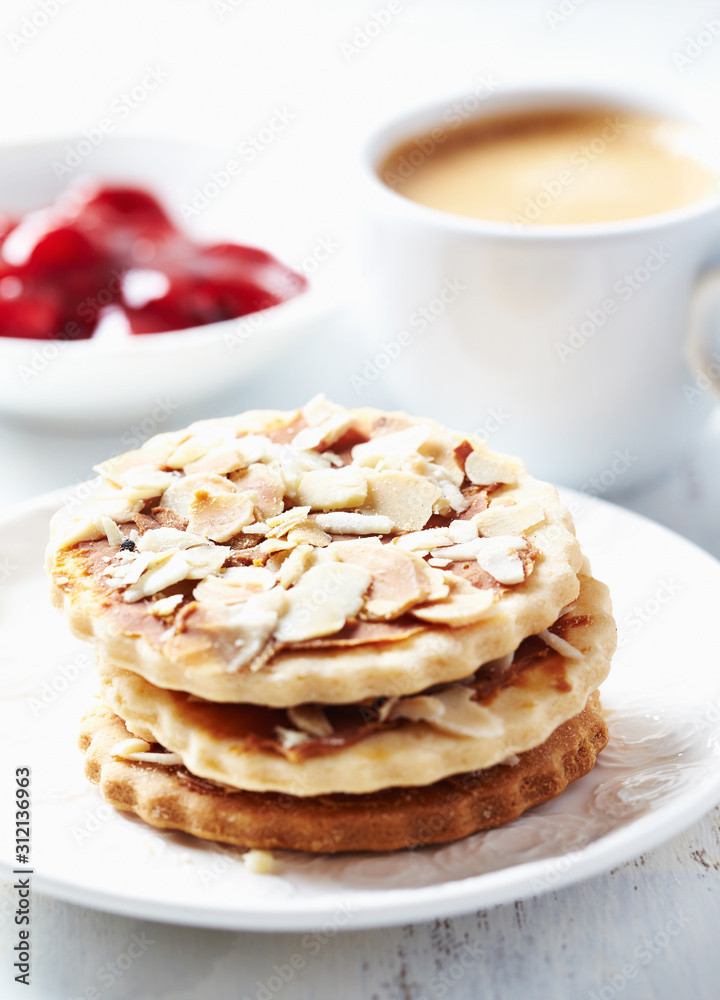 Almond cookies, cup of coffee and jam on white background. Close up. Almond cookies, cup of coffee and jam on white background. Close up.