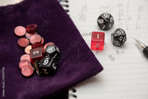 Set of pen, notebook, tokens and dices to play role game like dungeons and dragons.