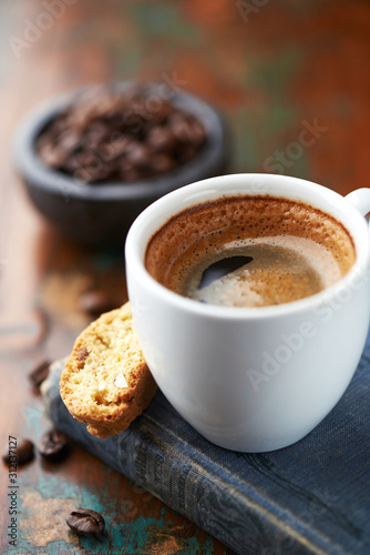 Cup of coffee with cantuccini (Italian cookies) on rustic wooden background. Close up. 
