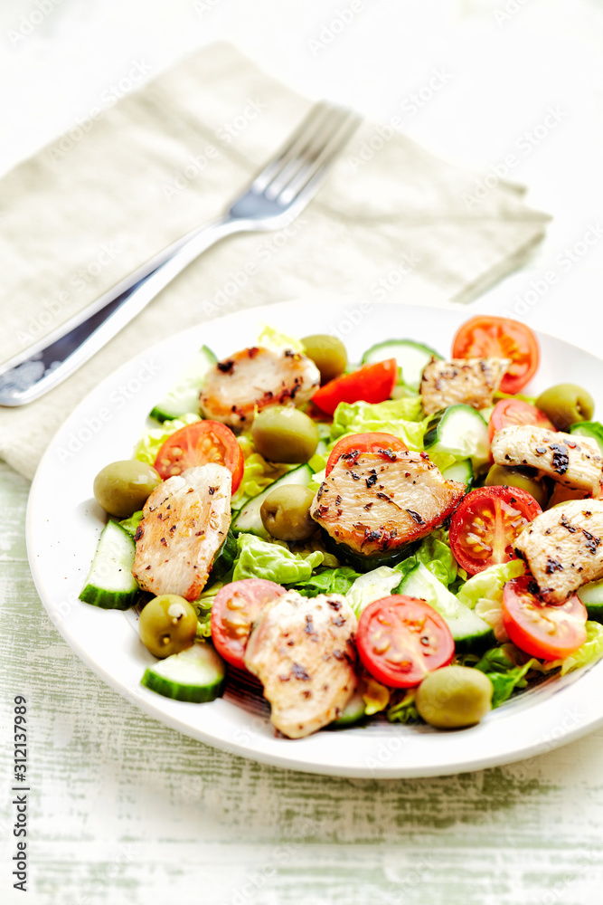 Fried chicken breast with cherry tomatoes, green olives and cucumber. Fried chicken breast with cherry tomatoes, green olives and cucumber.