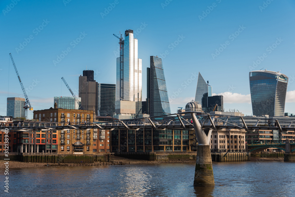 Tall Buildings in City of London Financial District and the Millennium Bridge Crossing Thames River Tall Buildings in City of London Financial District and the Millennium Bridge Crossing Thames River