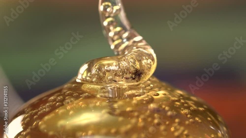 Golden sweetener syrup squeezing out spiralling macro extreme close up detail with bubbles