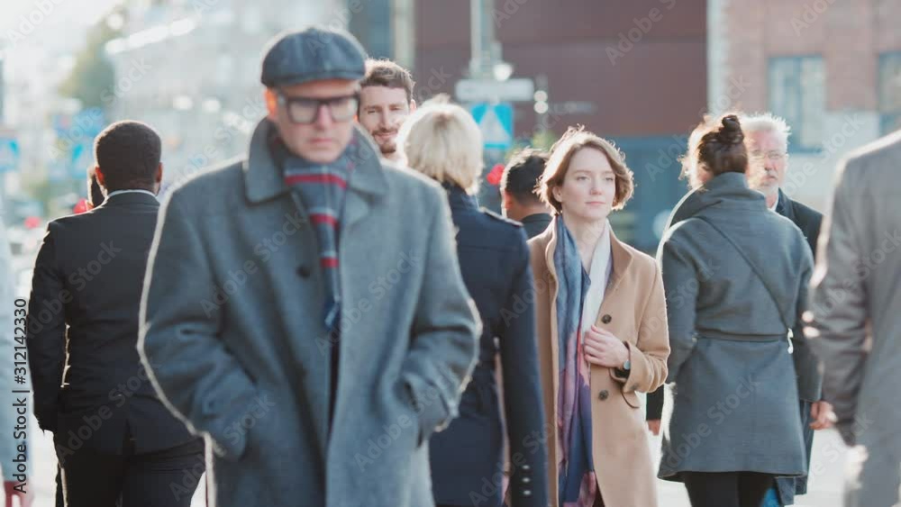 Diverse and Multicultural Office Managers and Business People Commute to Work in the Morning or from Office on a Sunny Day on Foot. Pedestrians are Smart Casually Dressed. They Look Successful. Diverse and Multicultural Office Managers and Business People Commute to Work in the Morning or from Office on a Sunny Day on Foot. Pedestrians are Smart Casually Dressed. They Look Successful.