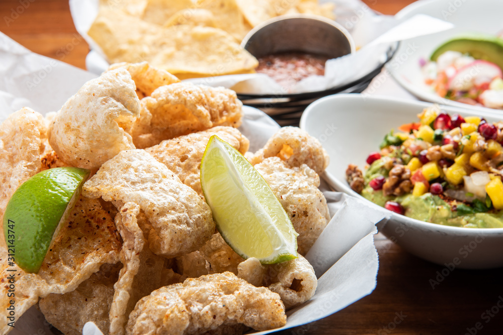 Pork rinds with guacamole on traditional Mexican comal Stock Photo