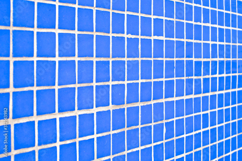 Pattern of fine small light blue tiles in angled perspective view.