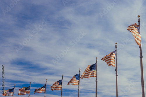 american flags in front of blue sky