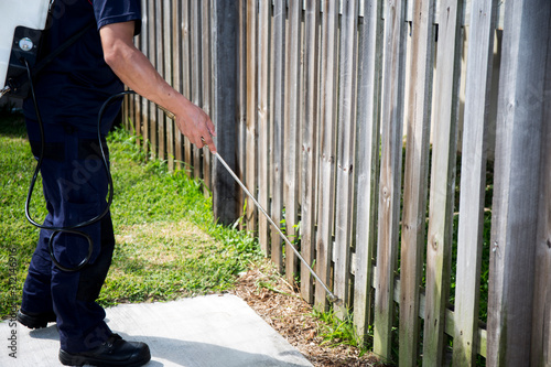 Pest Control Worker Spraying Pesticide outside the house photo