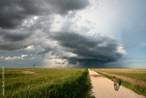 A man photographing a supercell storm in wheat field photo