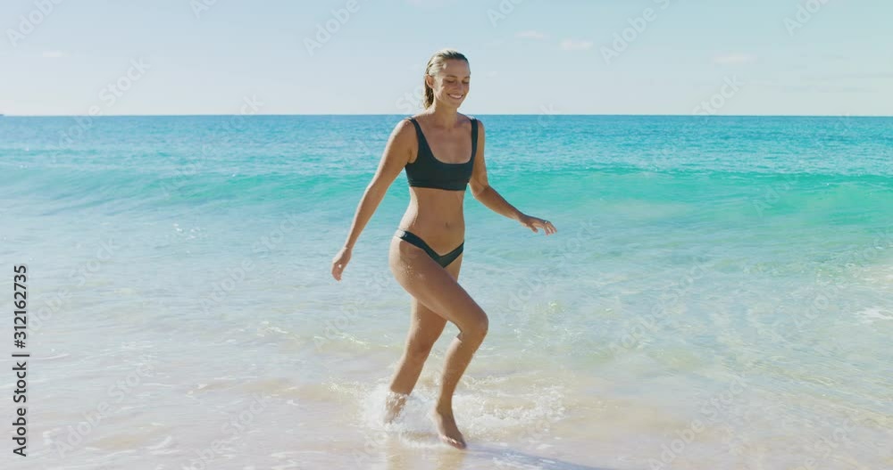 Young active woman enjoying herself at the beach on vacation, natural beauty concept, fit woman in a bikini Young active woman enjoying herself at the beach on vacation, natural beauty concept, fit woman in a bikini