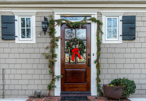 The front door to a house decorated with a holiday wreath